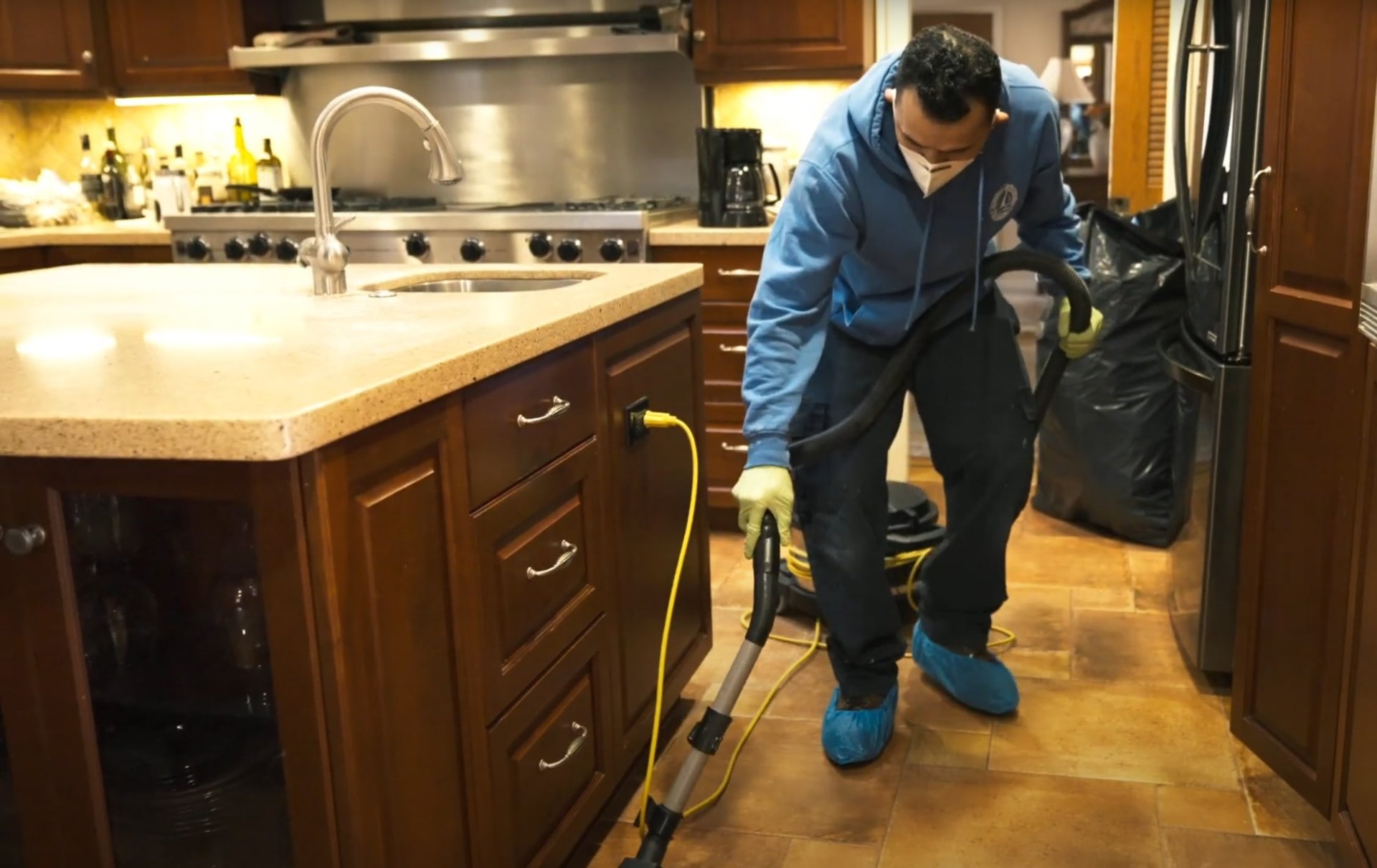 Professional water extraction and floor drying services in Huntersville, NC Water damage restoration specialist using professional equipment to extract water from kitchen flooring